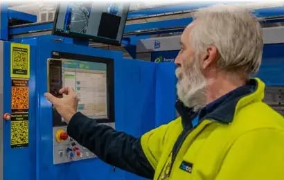 Knowby Integrate feature: An industrial worker using the Knowby interface to capture and sync SOP data via email and webhooks for system integration.