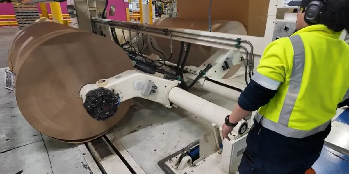 Operator in hi-vis at a paper machine in an Opal factory